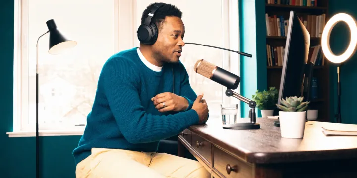 Host recording a podcast episode at a home studio desk